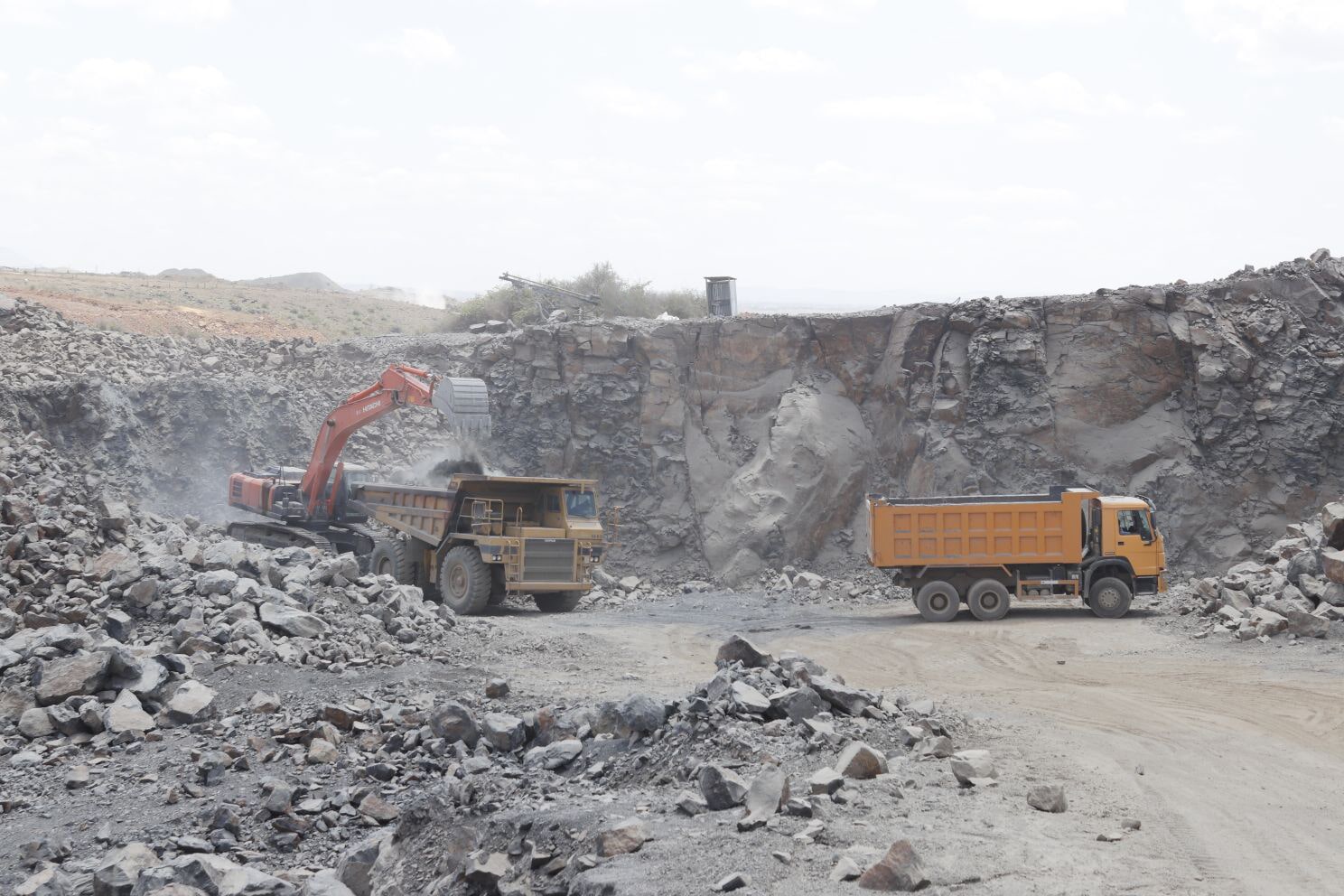 Excavator and trucks working in the quarry
